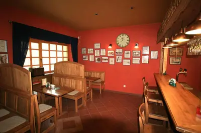 a dining room with a table and a clock on the wall at Penzion Coupe in Příbram