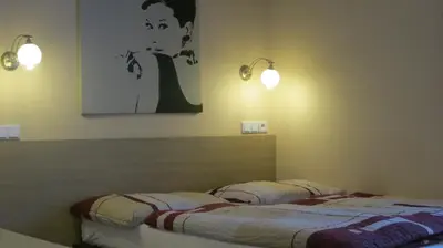 a bedroom with two beds and two lights on the wall at Penzion Coupe in Příbram