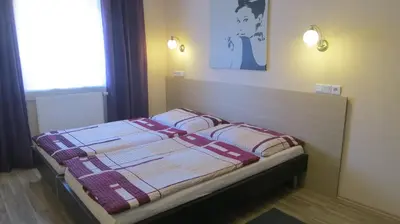 a bedroom with a bed with a blanket on it at Penzion Coupe in Příbram