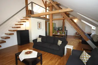 a living room with a couch and a staircase at River View Residence in Prague