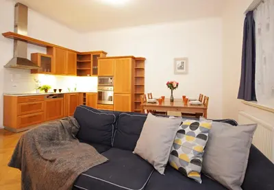 a living room with a couch and a kitchen at Prague Central Residence in Prague