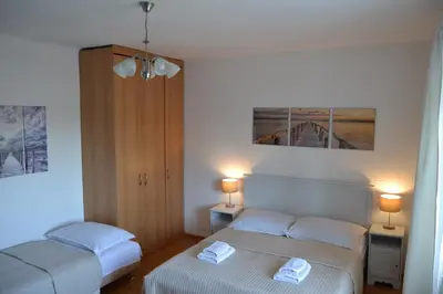 two beds in a small room with two lamps at Pension Nika in Prague