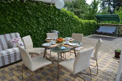 a patio with a table with white chairs at Pension Nika in Prague