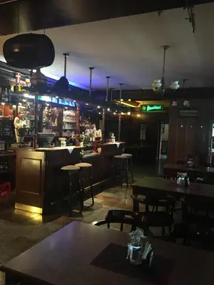 a restaurant with tables and a bar at night at Hotel V Pivovaře Davle in Davle