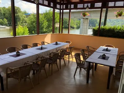 a room with tables and chairs and a large window at Hotel V Pivovaře Davle in Davle