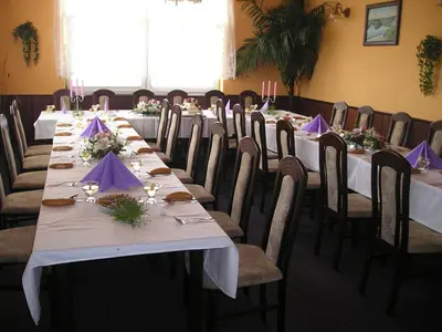 a conference room with long tables and chairs with purple napkins at Hotel V Pivovaře Davle in Davle