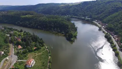 an aerial view of a river with trees and a house at Hotel V Pivovaře Davle in Davle