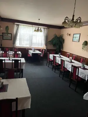 a dining room with white tables and red chairs at Hotel V Pivovaře Davle in Davle