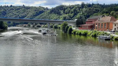 a boat traveling down a river under a bridge at Hotel V Pivovaře Davle in Davle