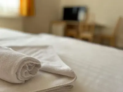 a pile of white towels sitting on a bed at Pension Fontana in Poděbrady