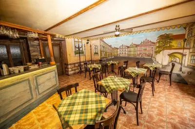 a restaurant with tables and chairs and a painting on the wall at Pension Fontana in Poděbrady