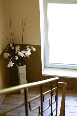 a white vase with flowers in it next to a window at Pension Fontana in Poděbrady