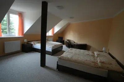 a bedroom with two beds and a large window at Toscca in Čelákovice