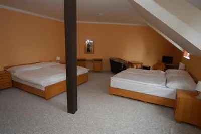 a hotel room with two beds and a desk at Toscca in Čelákovice