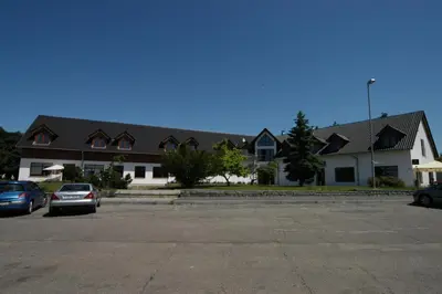 a large building with cars parked in a parking lot at Toscca in Čelákovice