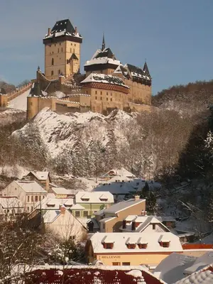 a large castle on top of a snowy mountain at Pension a Restaurace Vyhlídka in Karlštejn