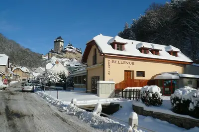 a building on a street covered in snow at Pension a Restaurace Vyhlídka in Karlštejn