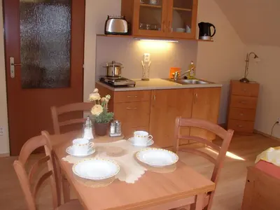 a kitchen with a wooden table with plates on it at Pension a Restaurace Vyhlídka in Karlštejn
