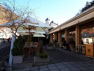 a street with tables and chairs and buildings at Pension a Restaurace Vyhlídka in Karlštejn