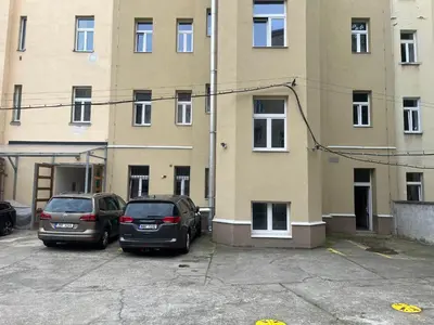 two cars parked in a parking lot in front of a building at Apartments Emma in Prague