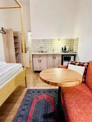 a room with a couch and a table and a kitchen at Apartments Emma in Prague