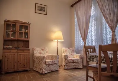a living room with two chairs and a lamp at Apartments Emma in Prague