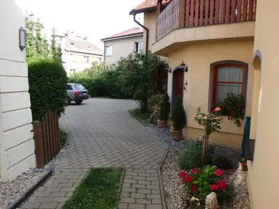 a brick driveway next to a house with a car at Pension Centrum in Ricany