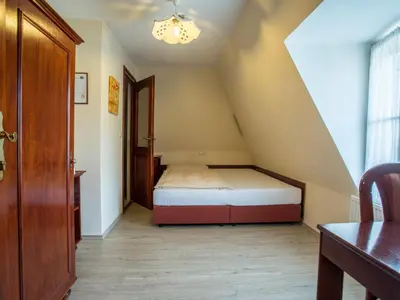 a small room with a bed in the attic at Pension Centrum in Ricany