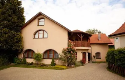 a large white house with a balcony on a driveway at Pension Centrum in Ricany