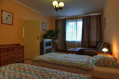 a bedroom with two beds and a dresser and a television at Apartments Letna in Prague