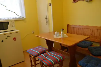 a small kitchen with a wooden table and stools at Apartments Letna in Prague