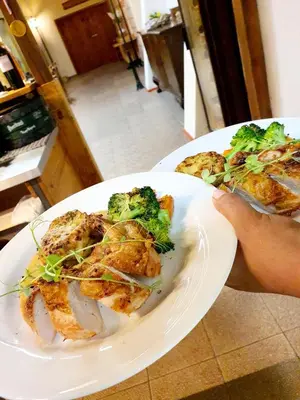 a person holding a plate of food with broccoli on it at Resort Lesní Lázně in Zvánovice