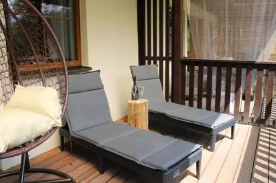 a porch with a swinging chair on a patio at Resort Lesní Lázně in Zvánovice