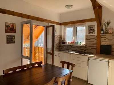 a kitchen with a wooden table and a dining room at U mě v domě 26 in Dubá