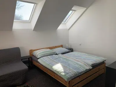 a bedroom with a bed and two windows at U mě v domě 26 in Dubá