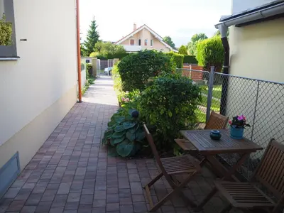 a patio with two chairs and a table and a fence at Apartmány U Václava - 7 minut od letiště Václava Havla - parkování zdarma in Kněževes