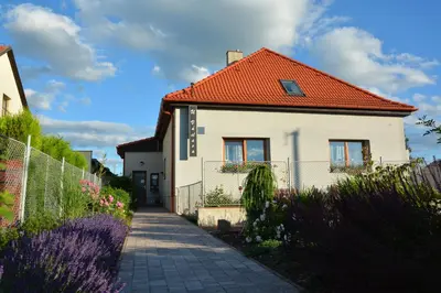 a white house with an orange roof at Apartmány U Václava - 7 minut od letiště Václava Havla - parkování zdarma in Kněževes
