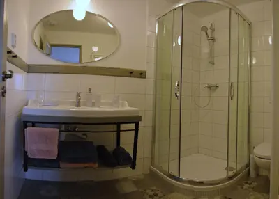 a bathroom with a sink and a shower with a mirror at Apartmány U Václava - 7 minut od letiště Václava Havla - parkování zdarma in Kněževes