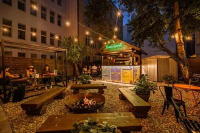 a restaurant with a fire pit in a courtyard at night at Prague Dream Hostel in Prague