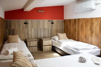 a room with two beds and a red wall at Prague Dream Hostel in Prague