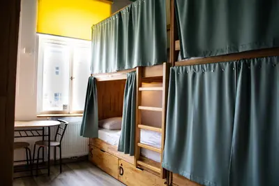 a room with a bunk bed with a table and a tableablish at Prague Dream Hostel in Prague