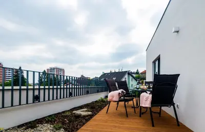 a kitchen with white cabinets and a table and chairs at Residence Trafick in Prague