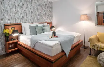 a bedroom with a large bed with a wooden headboard at 4 Elements Apartments in Prague