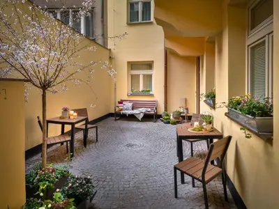 a courtyard with tables and chairs in a building at 4 Elements Apartments in Prague