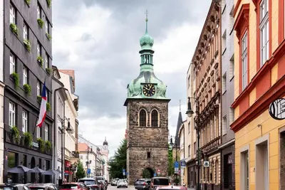 a tall tower with a clock on it on a city street at 4 Elements Apartments in Prague