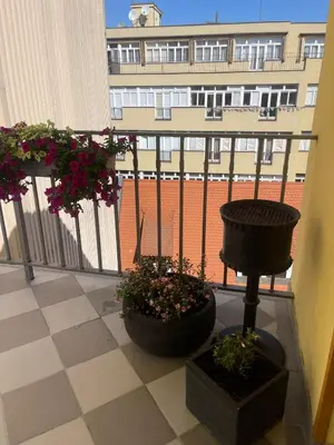 a balcony with two pots of flowers and a building at 4 Elements Apartments in Prague