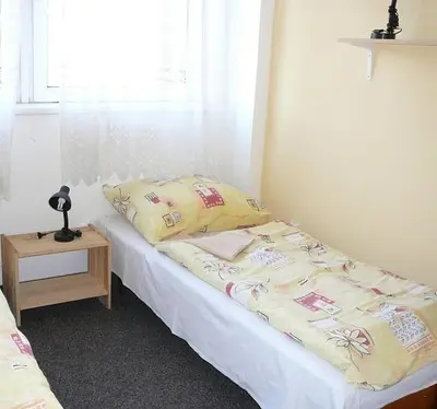 a bed with pillows and a table in a room at Sporthostel Scandinavia in Prague