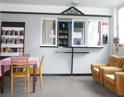 a restaurant with a table and chairs and a counter at Sporthostel Scandinavia in Prague