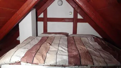 a bedroom with a bed in a attic at 14 Century Water Mill in Mořina