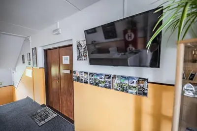 a hallway with a door and a television on a wall at Hotel Penzion Rohožník in Prague